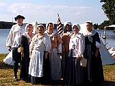 Colonial Revelers pause by a lake.